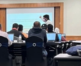 A classroom session with participants working at laptops.
