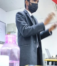 A facilitator explaining a concept beside a classroom whiteboard.