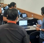 A small group gathered around a computer during a session.