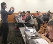 An instructor leading a workshop with seated participants.